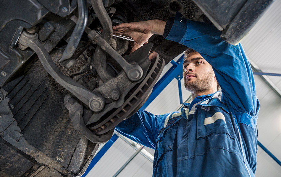 Mechanic checking suspension of car